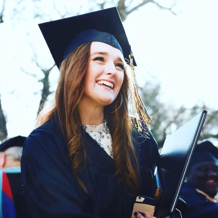Woman in her cap and gown smiling 