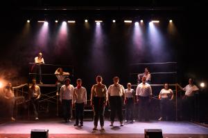 Group of actors standing tall in shadows in Working: The Musical Theatre production.