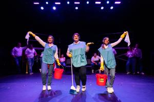 Three women posing with arms raised during Working: The Musical theatre production.
