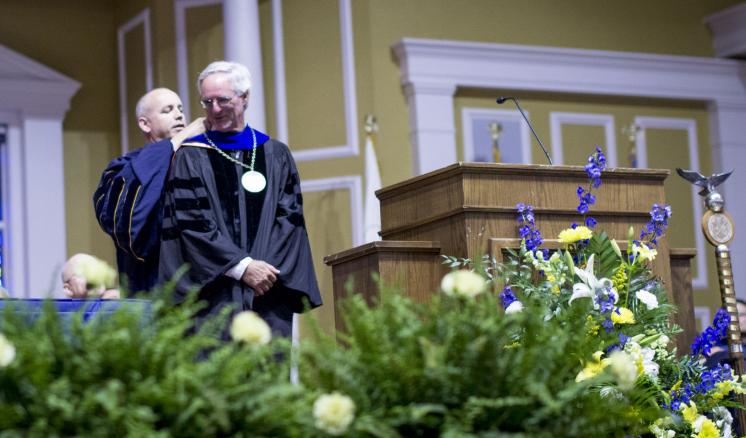 Man being awarded with academic medal during graduation ceremony 
