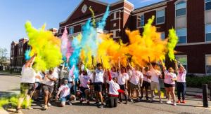 Students throwing color in the air following a color run race.