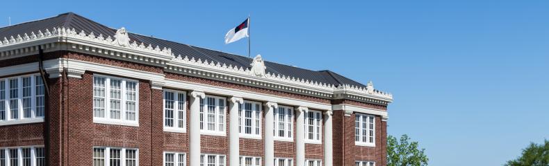 A brick academic building at East Texas Baptist University with a blue sky in the background.