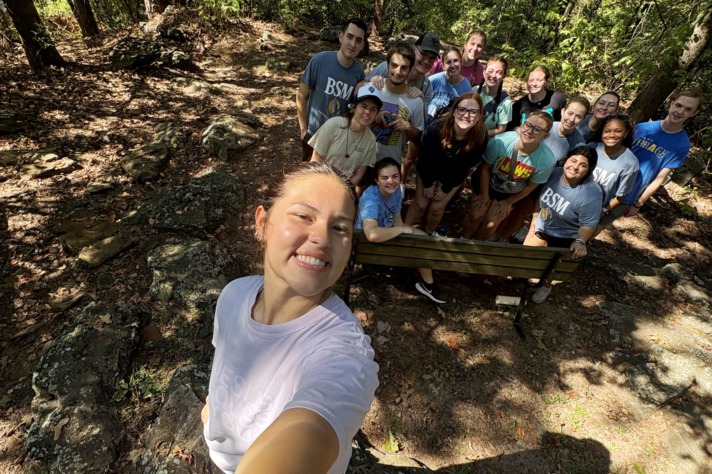 Group selfie of students in the woods during a retreat.