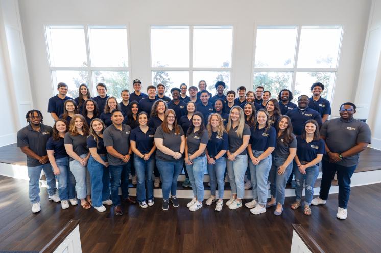 Large group picture of men and women smiling at the camera 