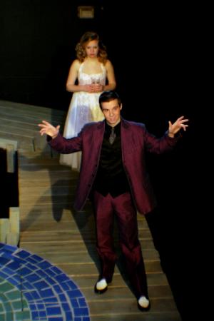 A man and woman standing on a staircase in formal clothing under dimly lit lighting
