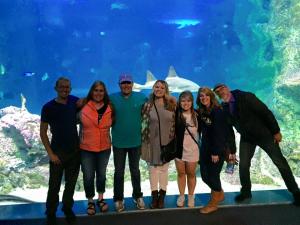 A group of people inside an aquarium standing in front of a tank