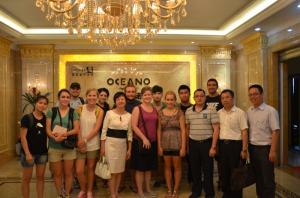 A group of people posing for a photo in a lavishly decorated room with a chandelier.