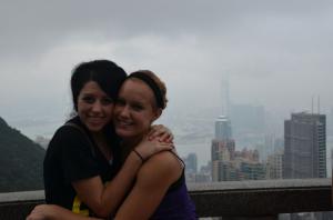 Two people embracing with a hazy cityscape in the background.