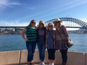 a group of people standing with a bridge in the background