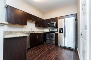 Modern kitchen with dark wood cabinets, stainless steel appliances, and granite countertops.