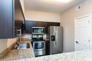 Modern kitchen with stainless steel appliances and dark cabinets.