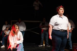 Two women in the foreground, one staring at the other in Working: The Musical Theatre production.