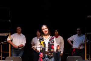 Woman smiling in foreground in Working: The Musical Theatre production.