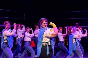 Group of women posing with arms up during Working: The Musical