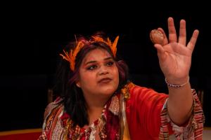 Woman staring at object in hand during Cagebirds Theatre Production