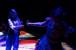 Two woman exchanging flower during Cagebirds Theatre Production 