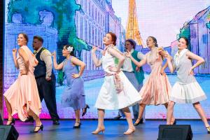 ETBU theatre students dancing together in formal clothing during a play on a stage
