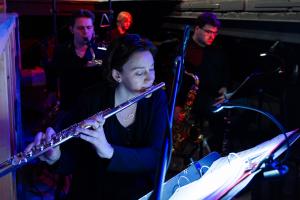 A group of people playing instruments in a band on a stage