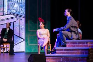 A man sat on brick stairs looking int othe distance on a stage 