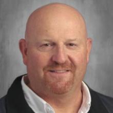 A man with a bald head wearing a black jacket