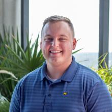 Bryce Hoffman ('19) A man smiling at the camera in front of window
