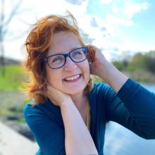 A women smiling at the camera outside