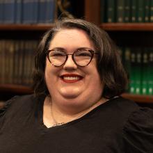 Woman standing in front of bookshelf 