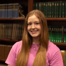 Woman standing in front of bookshelf