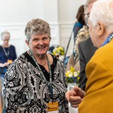 A group of people talking to one another at luncheon 