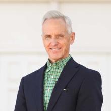a man standing outside in professional attire