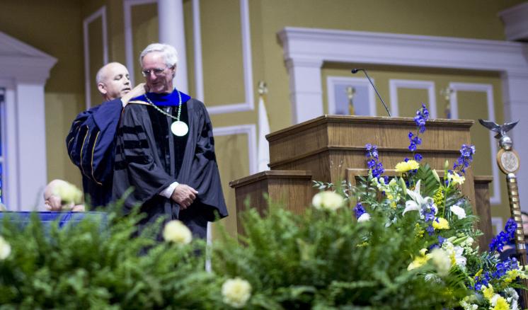 Man being awarded with academic medal during graduation ceremony