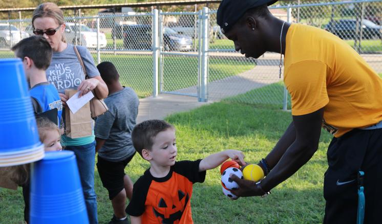 An ETBU freshman teaches a child how to play the throwing game