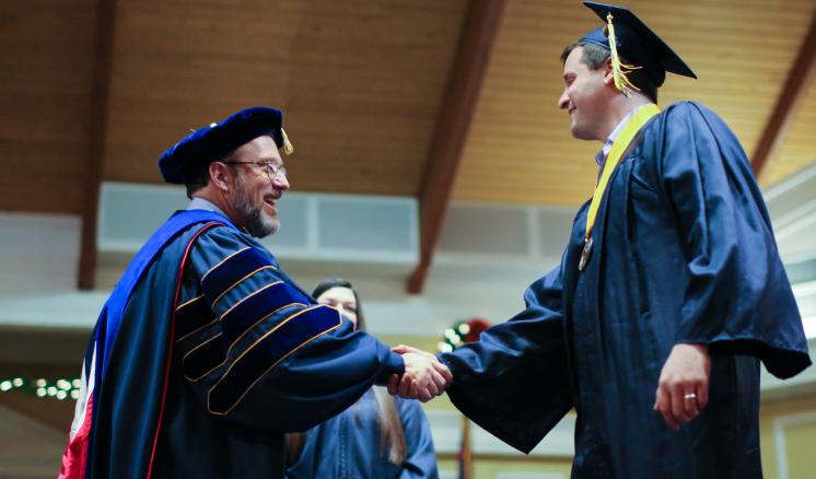 Student walking across stage during ceremony