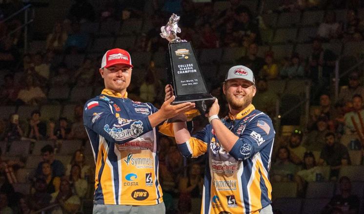 2 men in bass fishing apparrel holding up a trophy