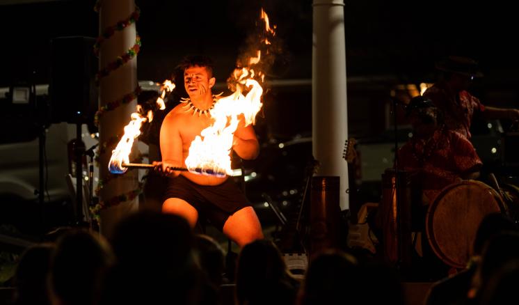 Man with a stick on fire doing and fire dance