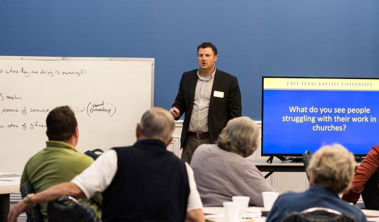 Man speaking to a group of adults