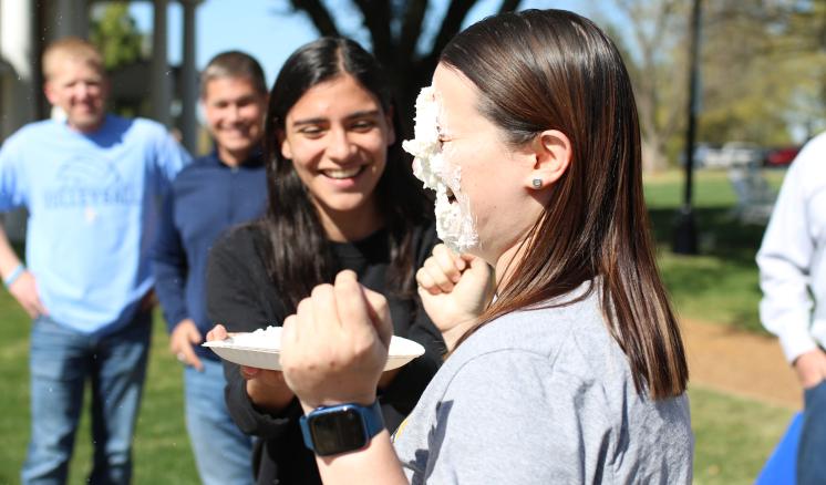 2022_pie_your_professor_img_1 Woman getting pied in the face by another woman