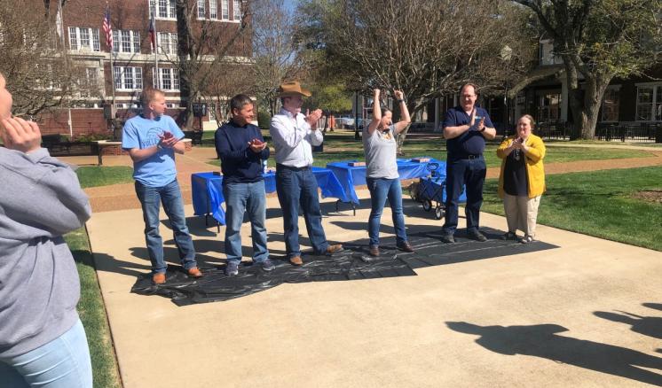 2022_pie_your_professor_img_2 Group of people standing on a black tarp outside