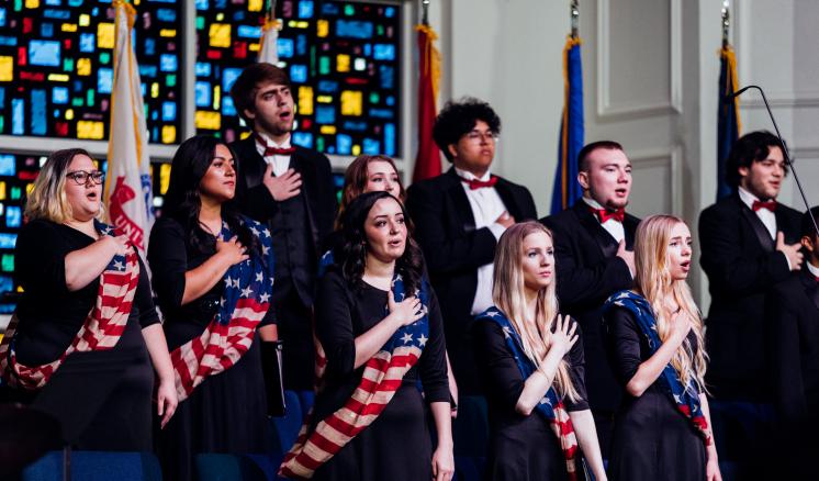 sam_b._hall_img_3 Choir students with their hands over their hearts with American Flag sashes on