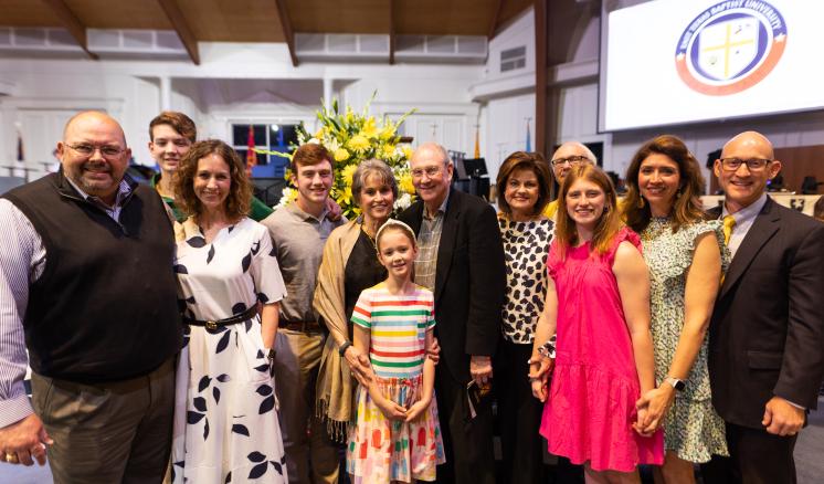 A group of men and women smiling at the camera in chapel