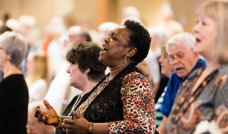 A group of older people singing in a chapel