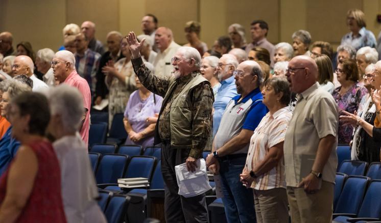 A group of older people worshipping in a chapel