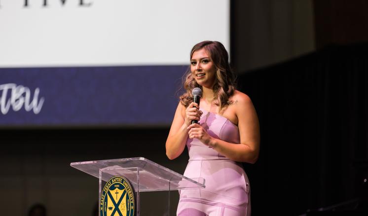 Woman speaking in front of a podium in a chapel