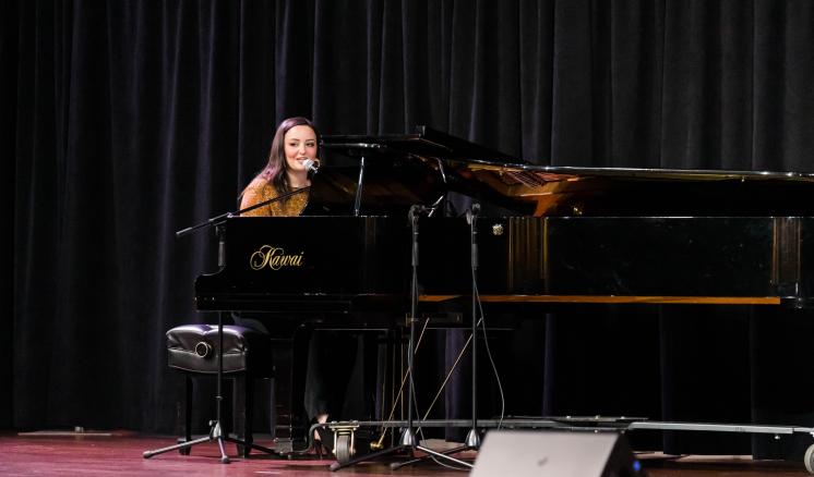 Women sitting at a grand piano singing