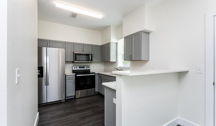 A kitchen with a white counter top next to a refrigerator freezer