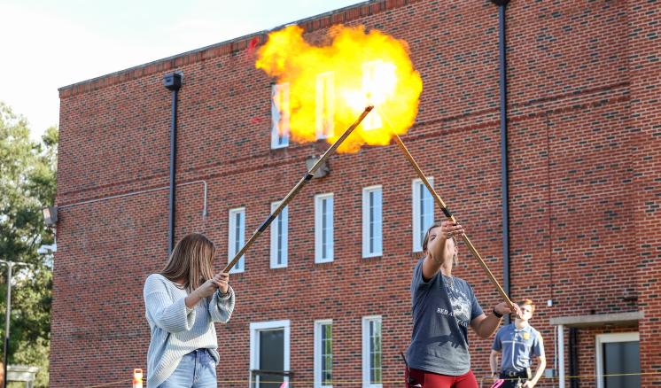A group of people standing in front of a building holding crossing torches