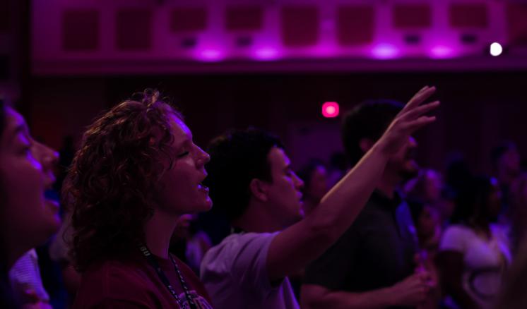 Students worshiping in a dark chapel 