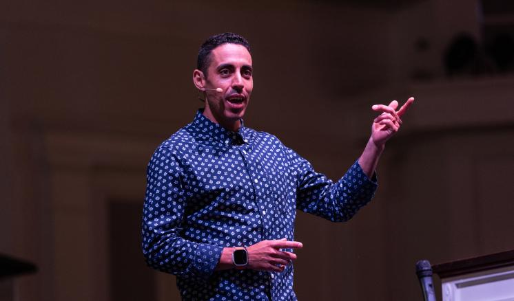 A man speaking with hand outstretched