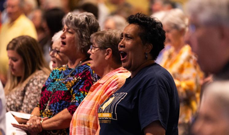 A crowd singing in a chapel.