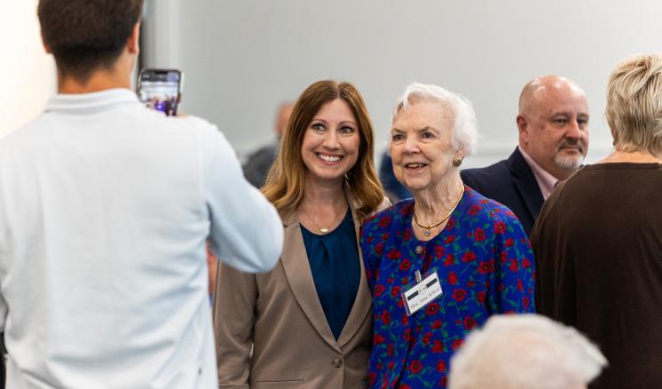 Image of man taking a picture of two women standing together 